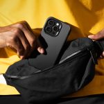 Person holding a phone with a Nimbus9 Cirrus 3 case in black, pulling it out of a black zippered bag