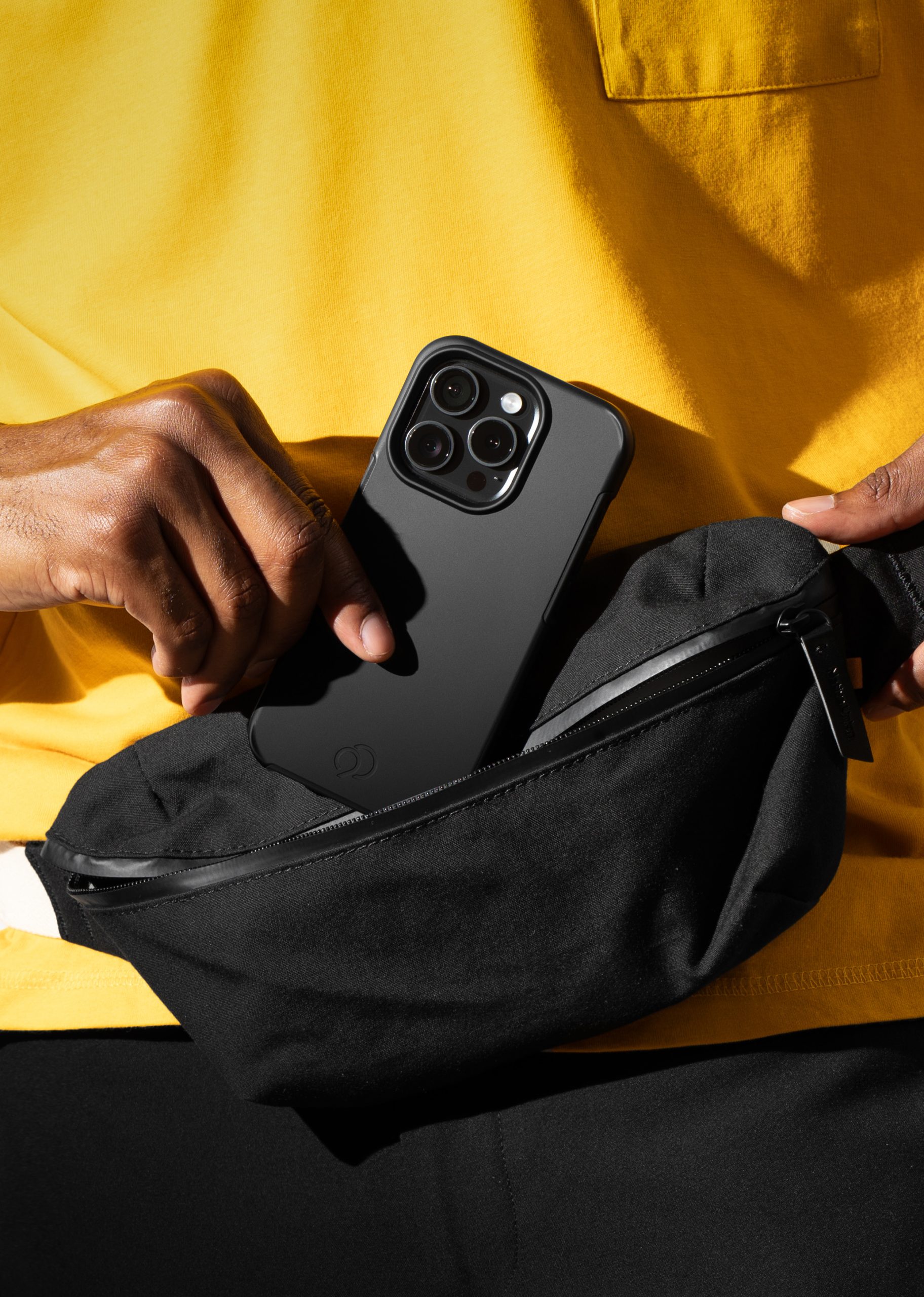 Person holding a phone with a Nimbus9 Cirrus 3 case in black, pulling it out of a black zippered bag